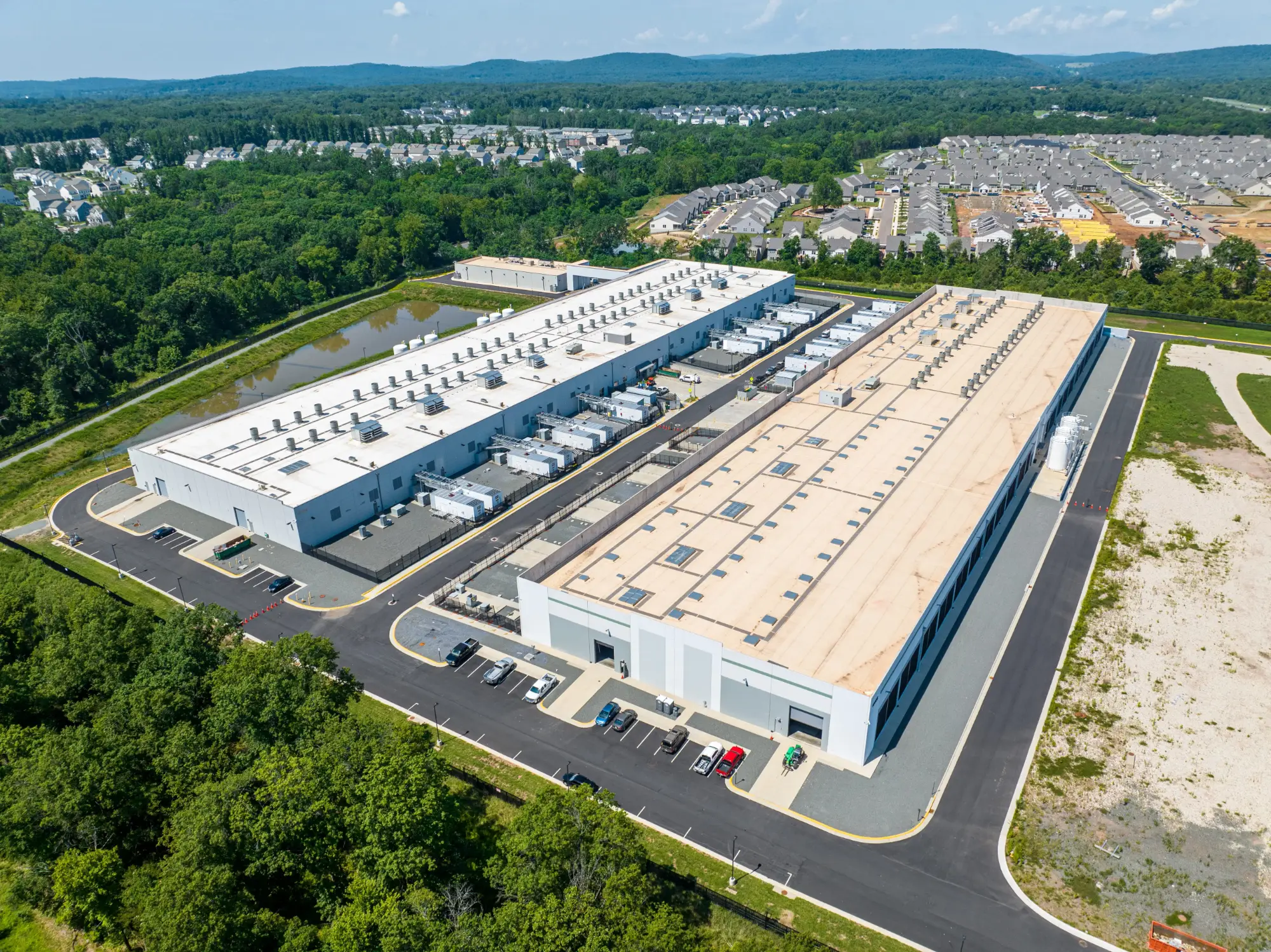 An aerial view of a large data center complex next to a suburban subdivision.